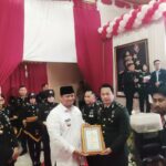 Sekda Banyuasin Erwin Ibrahim didampingi Kapolres Banyuasin AKBP Risnan Aldino beserta jajaran saat memberikan Piagam Penghargaan untuk IPDA Ropiyan Anggono saat puncak perayaan HUT Bhayangkara ke-80 di Mapolres Banyuasin, Rabu (1/07/2026) ( Foto : Otaritanews@gmail.com/Irwan September)